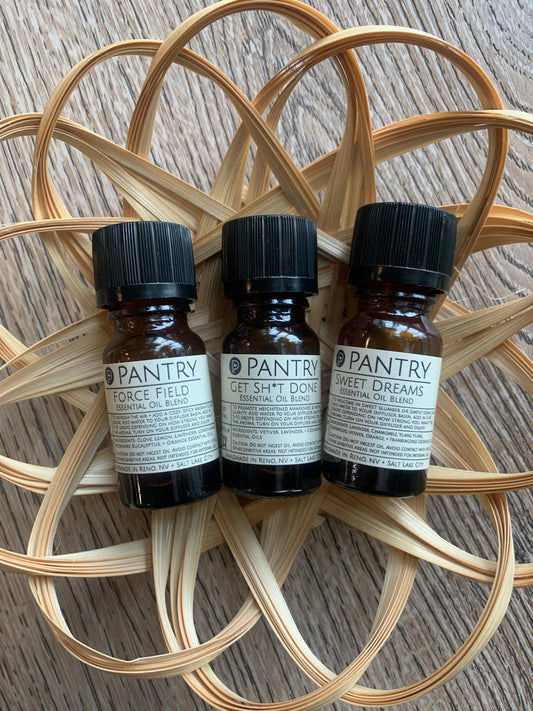 Essential oil blend bottles: three dark glass with black caps and Pantry labels