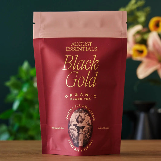 August Essentials black tea pouch front with large 'Black Gold' text