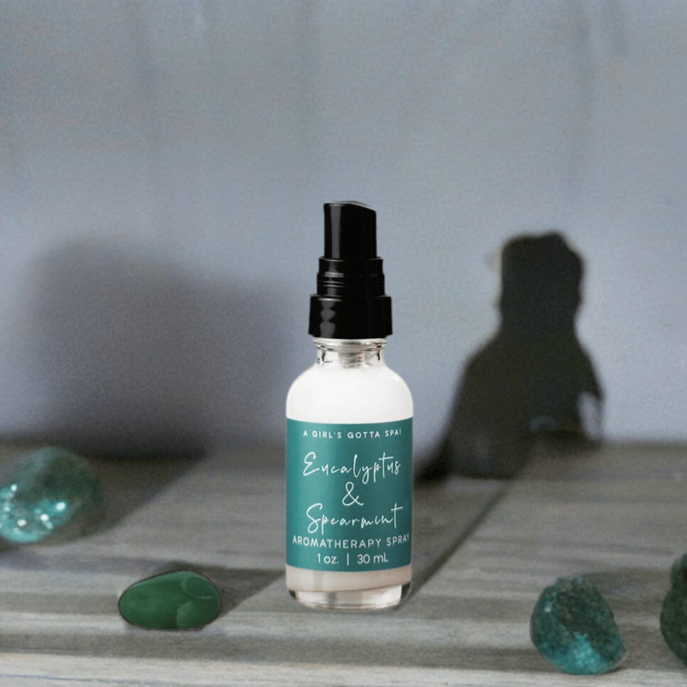 Eucalyptus and spearmint aromatherapy spray bottle on wood shelf with black mist top