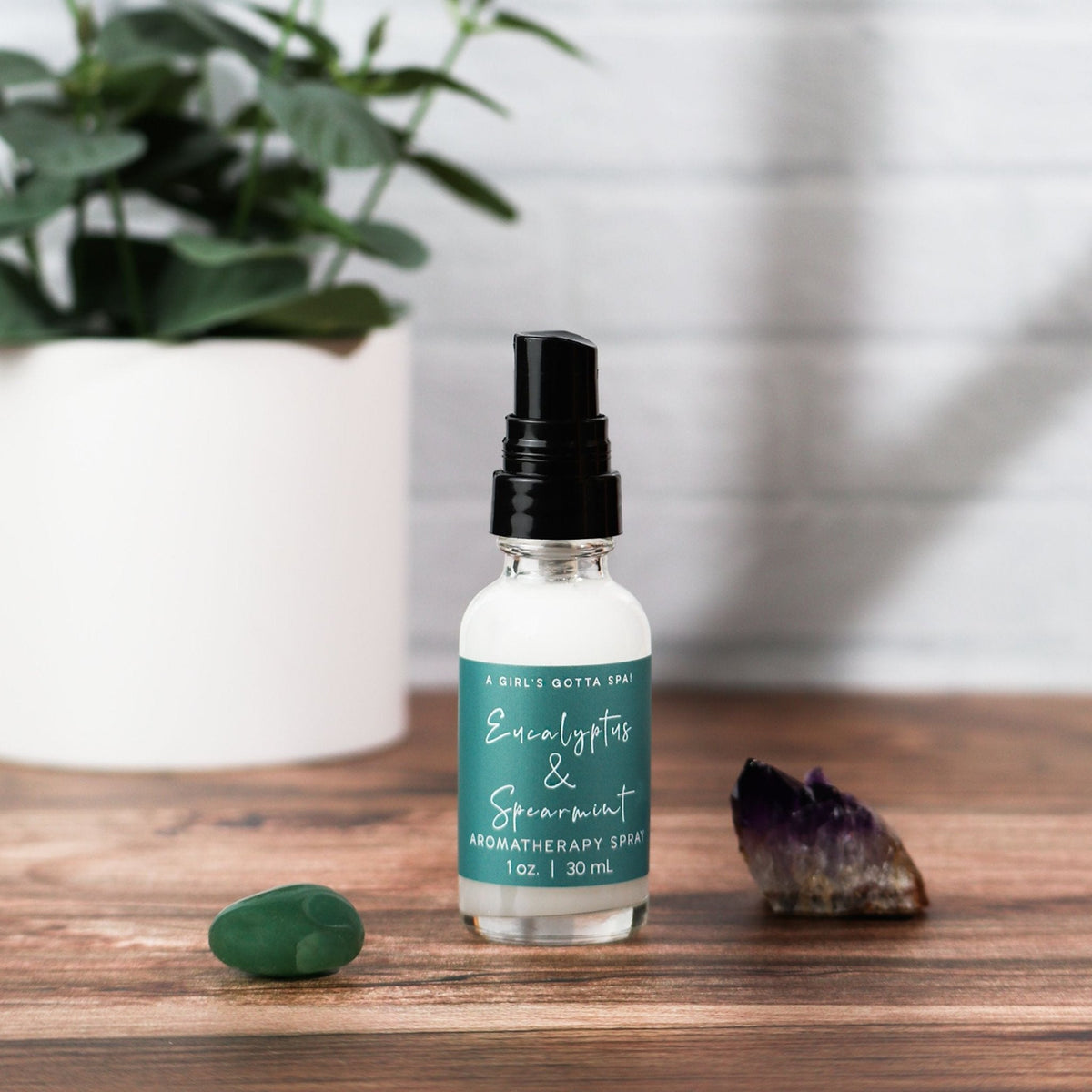 Eucalyptus and spearmint aromatherapy spray bottle on wooden table with black mist top