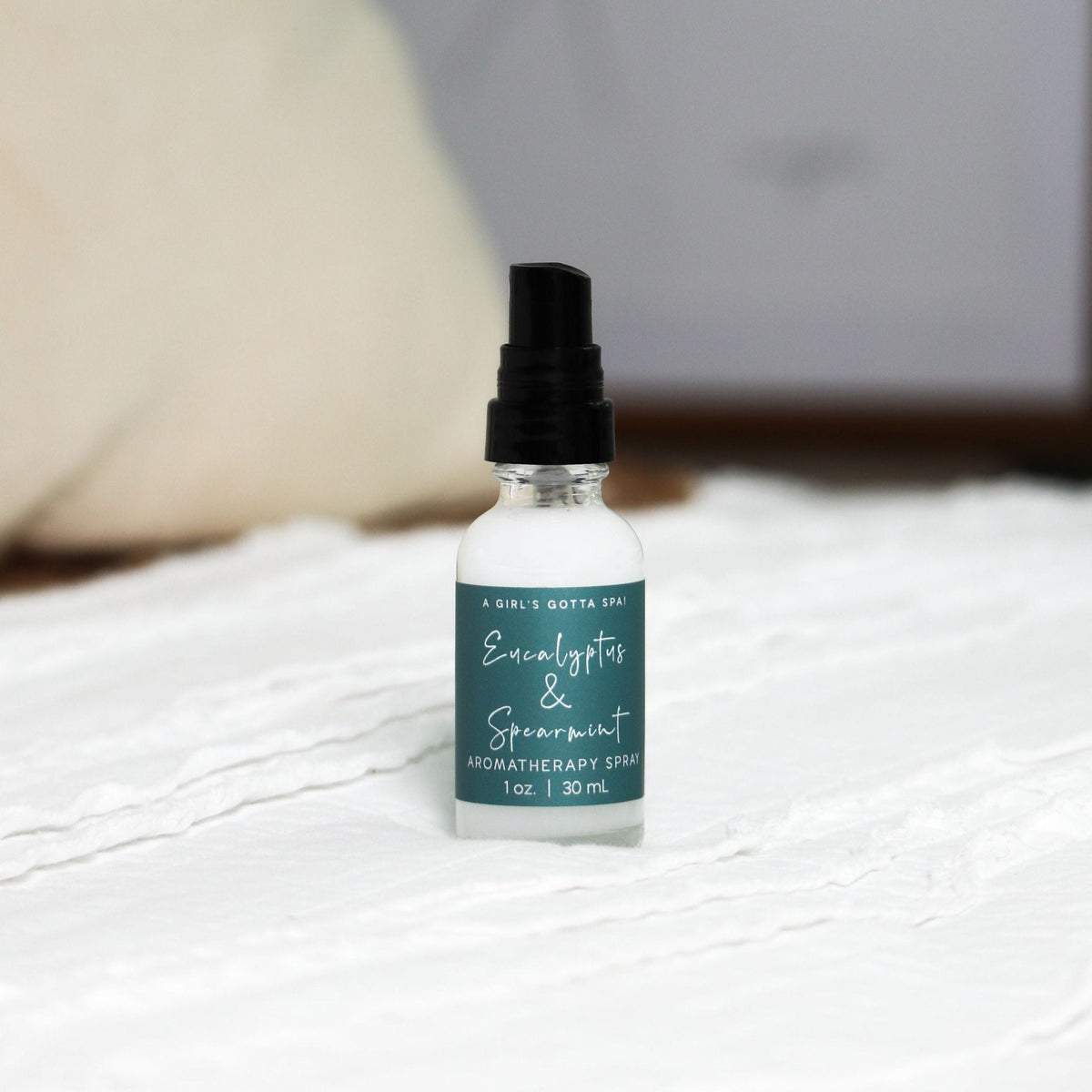 Eucalyptus and spearmint aromatherapy spray bottle with black mist top on white surface
