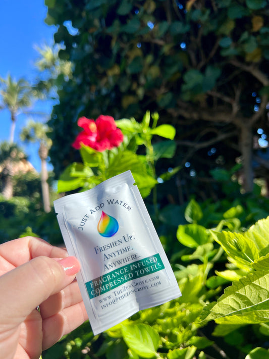 Compressed towel sachet labeled fragrance infused, held in hand