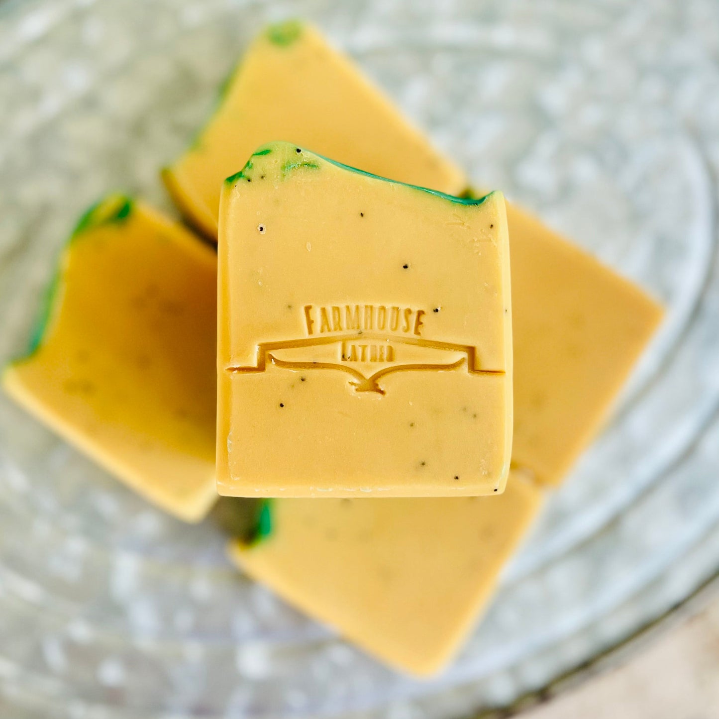 Yellow bar soap with teal swirls and FARMHOUSE logo, close-up