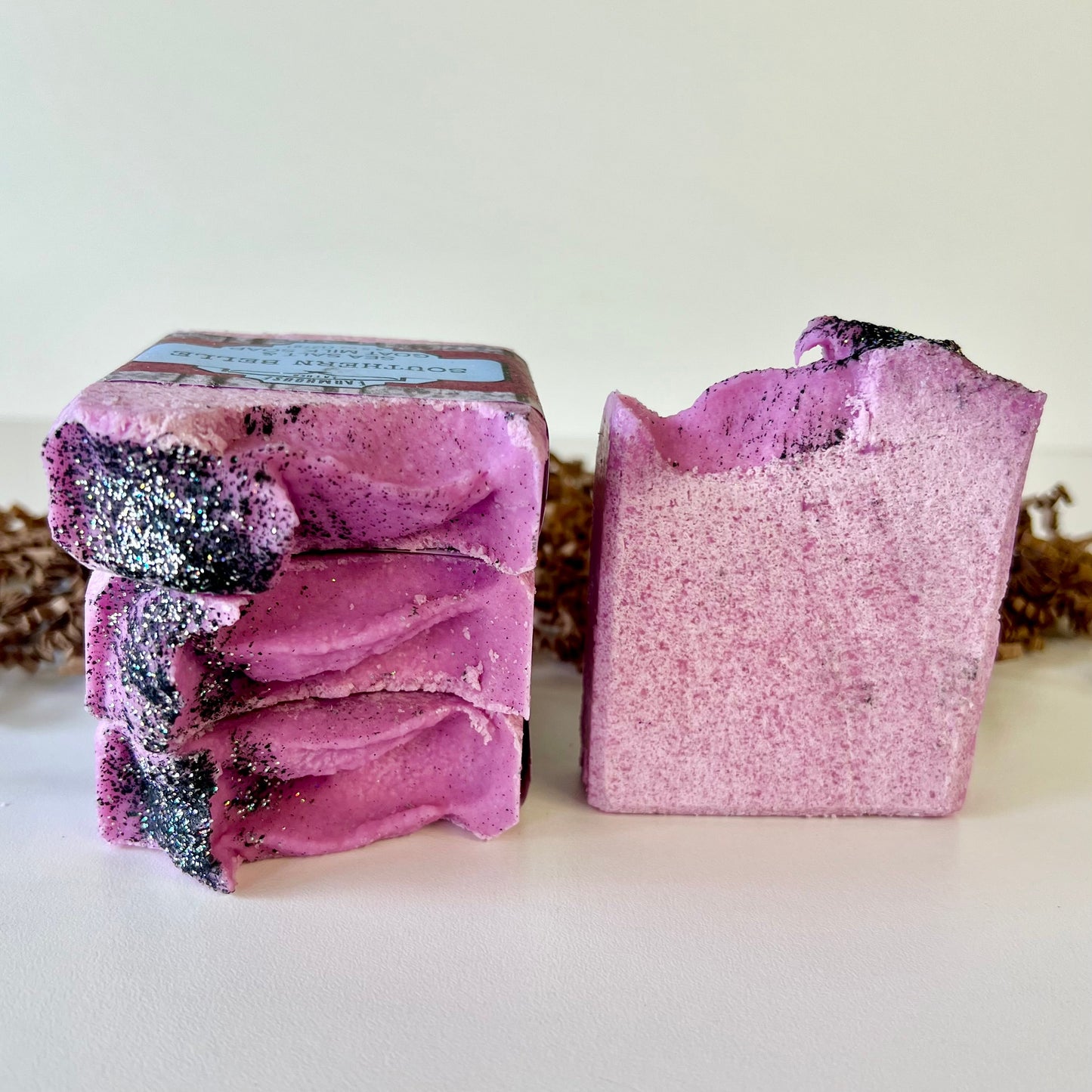Pink glitter-speckled sea salt soap bar, stacked, with top label