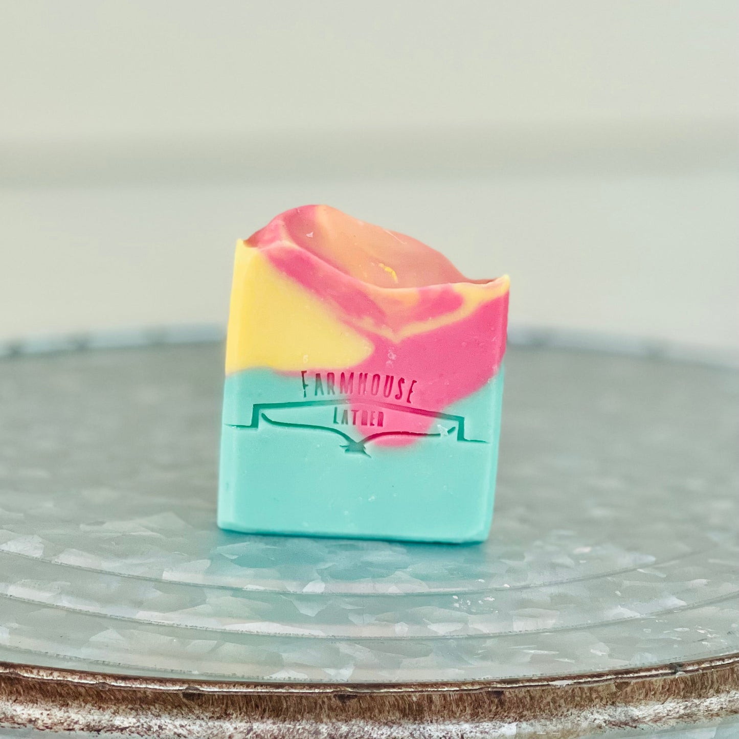 Marbled soap bar in teal, pink, and yellow with Farmhouse label, single view.