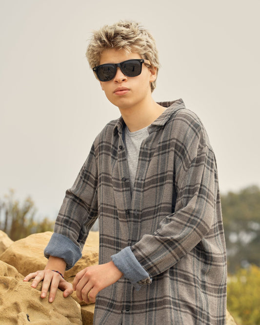 Polarized sunglasses worn with dark lenses and wood-look temples on a person.