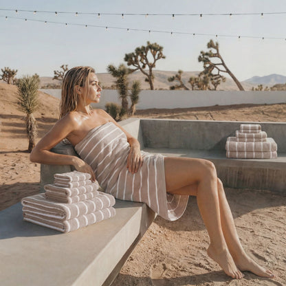 Plush cotton towels with light tan stripes, stacked and folded