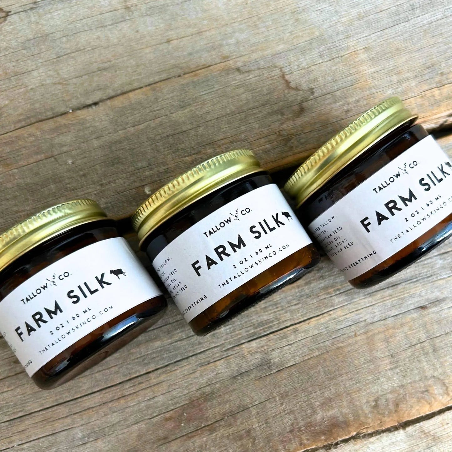 Farm Silk tallow moisturizer jars with green lids and white labels