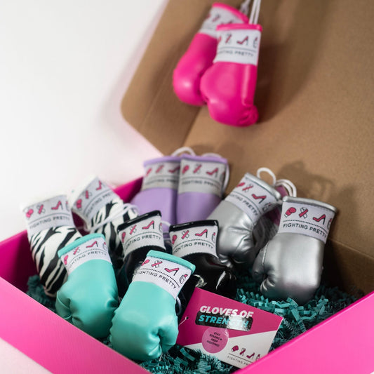 Assorted mini boxing gloves in box: pink, teal, silver, and magenta with laces