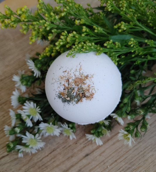 Round white bath bomb with brown and green speckles
