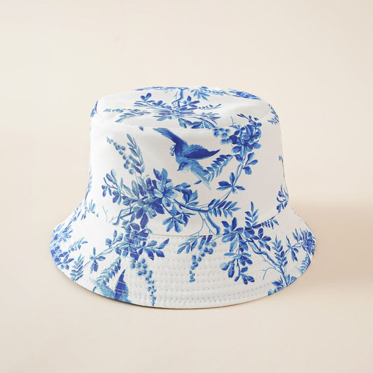 White bucket-style hat with blue floral and bird motif