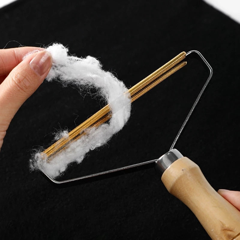 Lint remover brush with wooden handle lifting pet hair from fabric