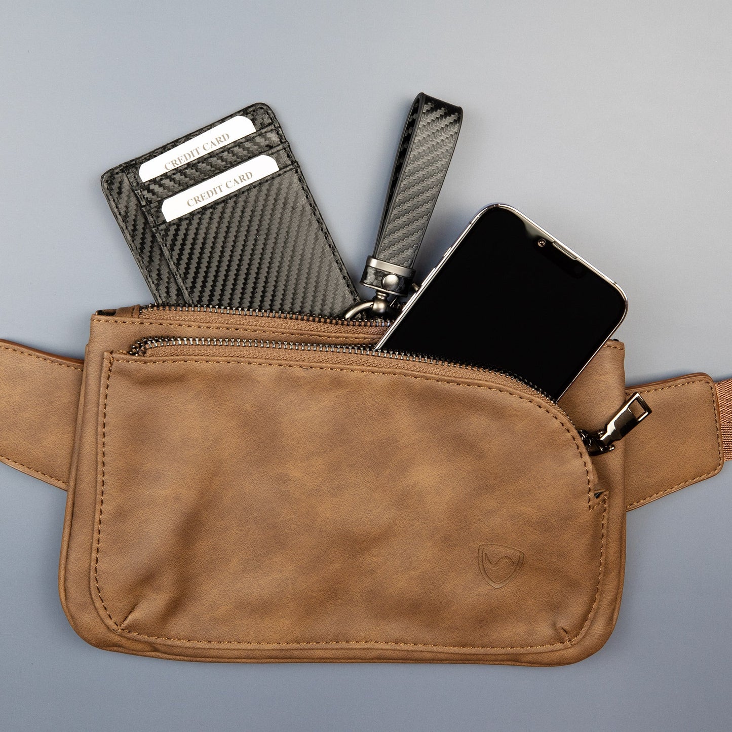 Vegan leather crossbody fanny pack with front zipper and metal logo accent