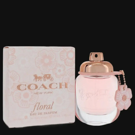 COACH Floral Eau de Parfum bottle with rose-gold cap and charm tag, next to matching box
