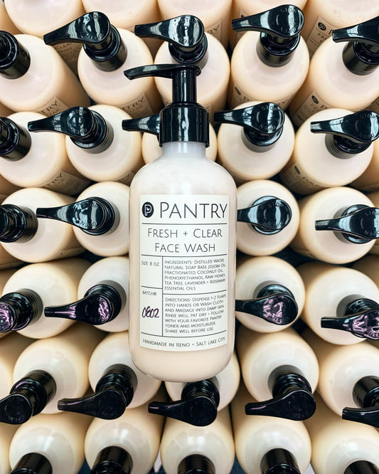 Face wash bottle, cream label with dark cap, front view