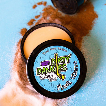 Hockey wax tin with black lid, blue Dirty Dangers label, and pale wax puck