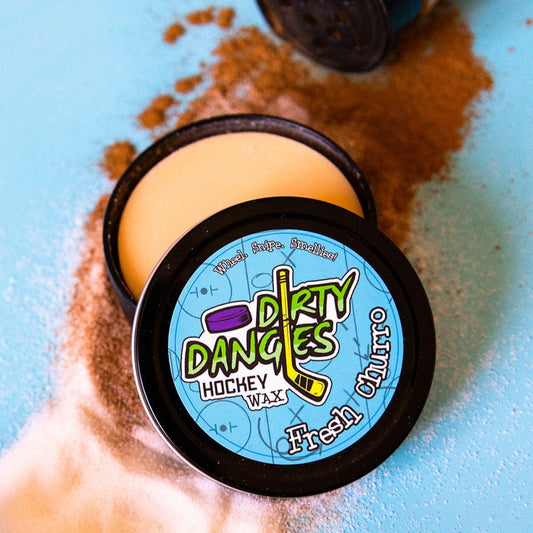 Hockey wax tin with black lid, blue Dirty Dangers label, and pale wax puck
