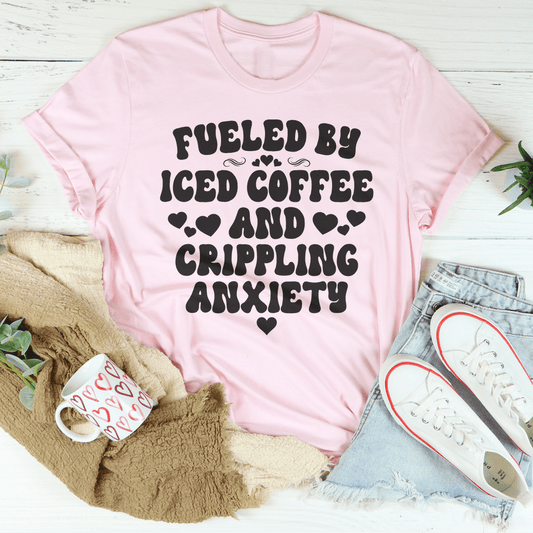Light pink T-shirt with black front text graphic: “Fueled by Iced Coffee...”
