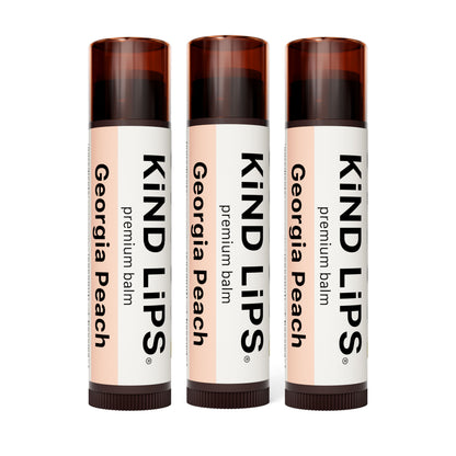 Three KIND LIPS premium lip balm sticks, Georgia Peach labels on dark brown caps