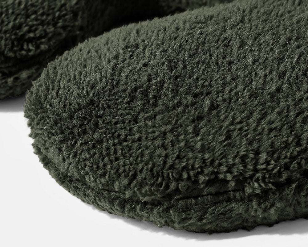 Close-up of dark green plush weighted neck pillow cover and stitched edge