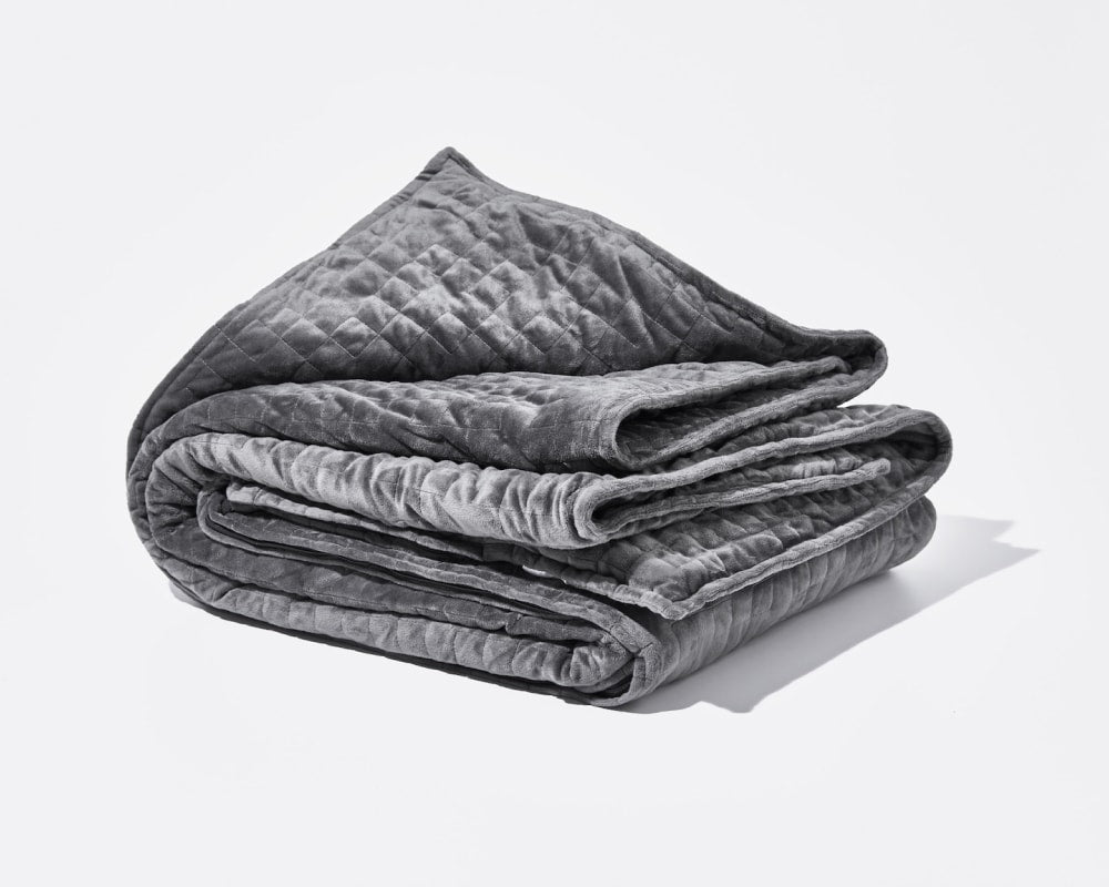 Folded grey weighted blanket with quilted texture and layered edges