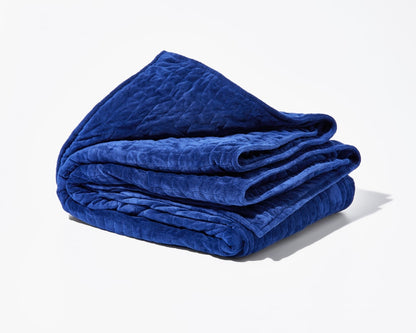 Folded blue weighted blanket with quilted texture and layered edges