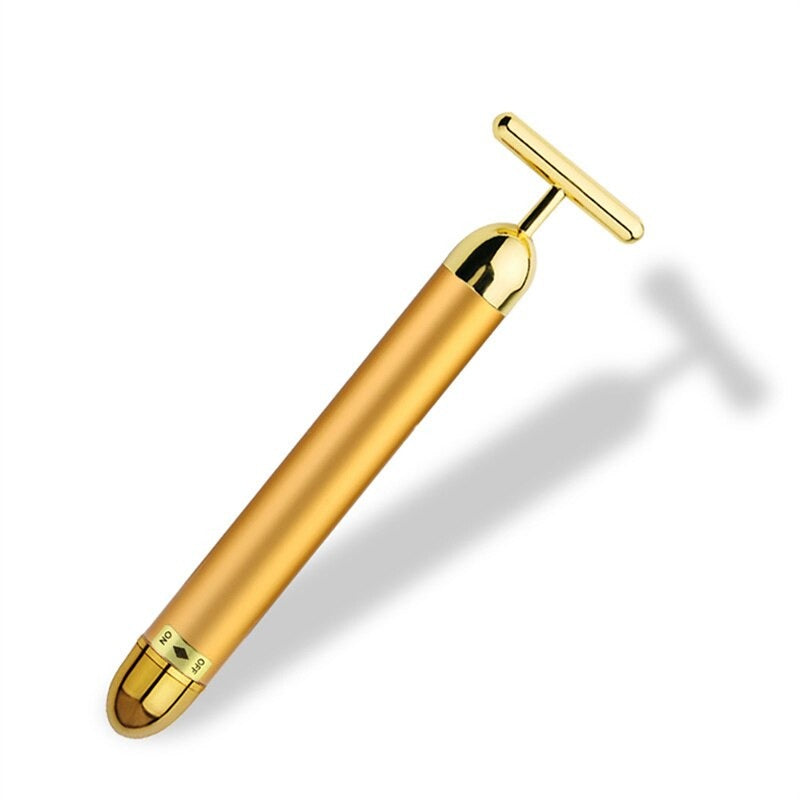 Gold T-shaped facial roller massager with cylindrical body and T bar head