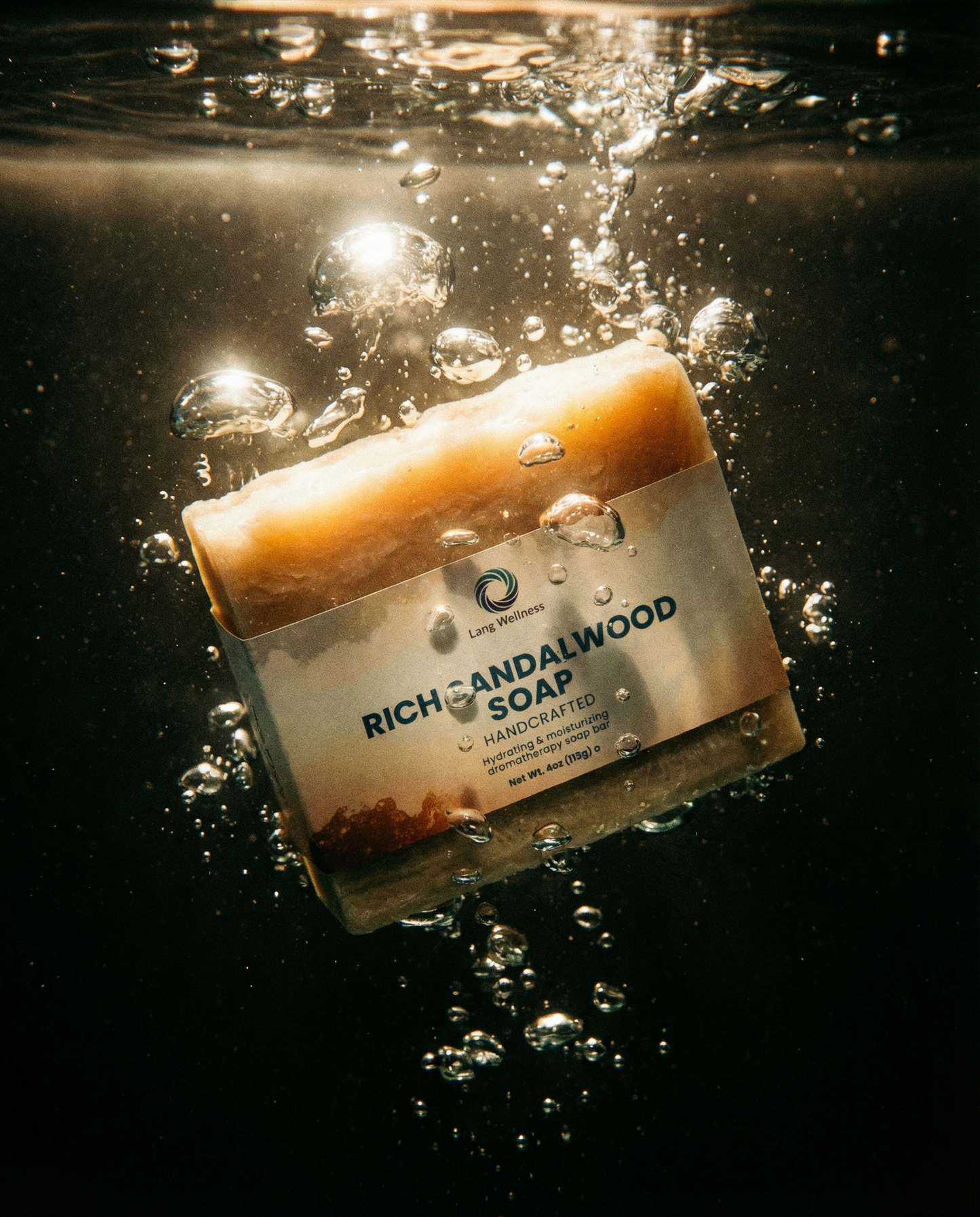 Rich sandalwood soap bar floating in water with bubbles, beige label facing up