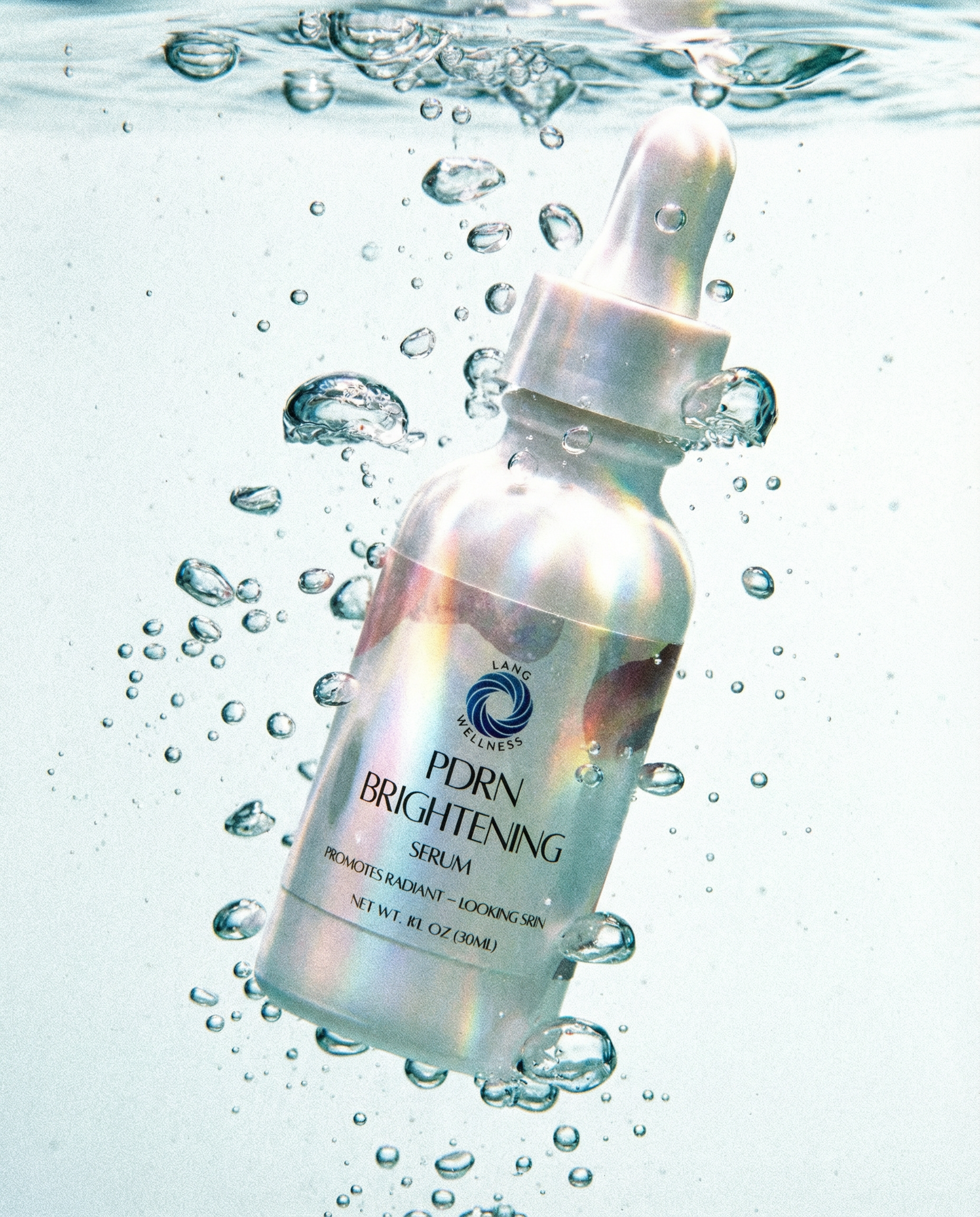 Brightening serum bottle with dropper, iridescent bottle highlights, droplets around