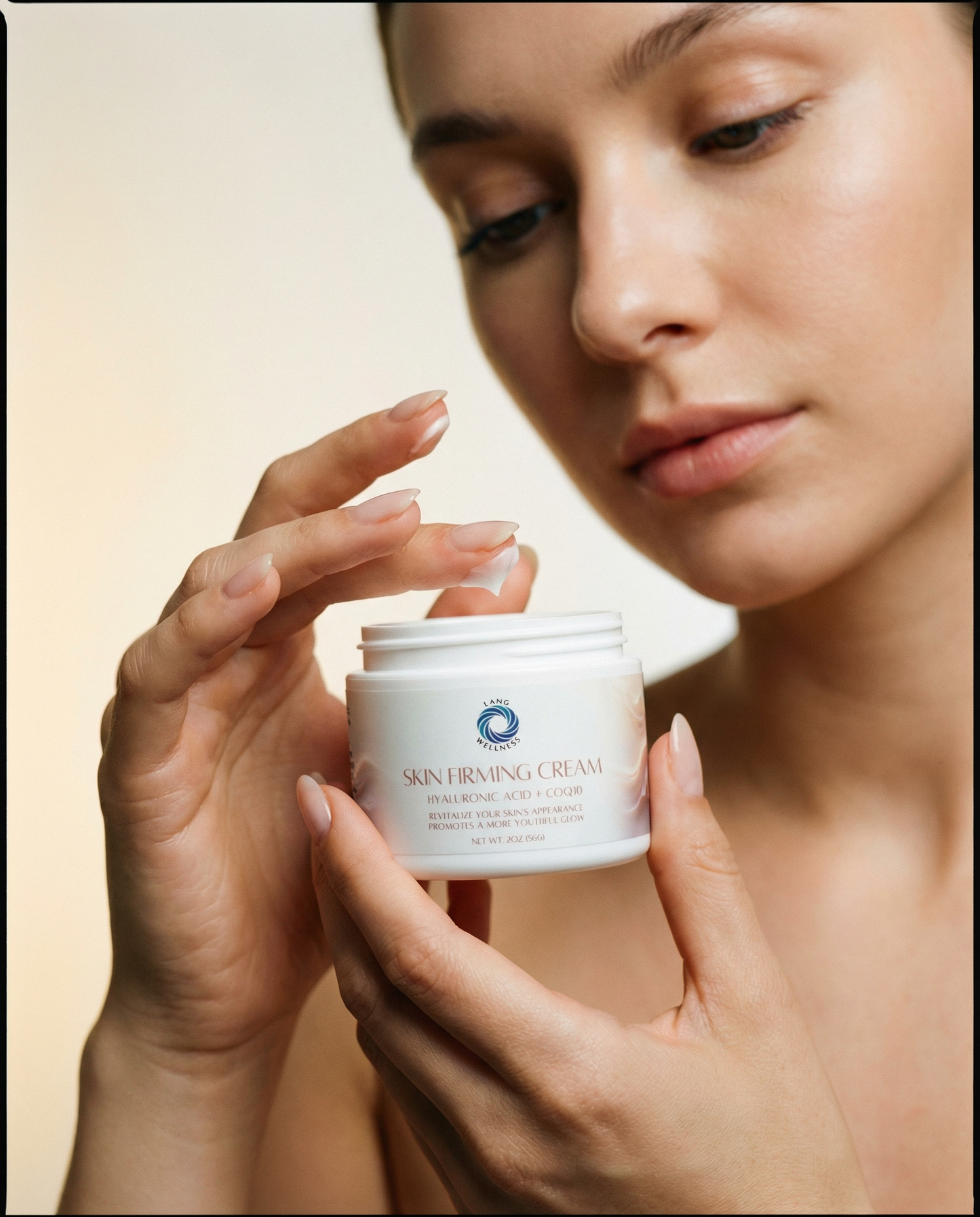 Skin firming cream jar held by hands near face, white lid and label