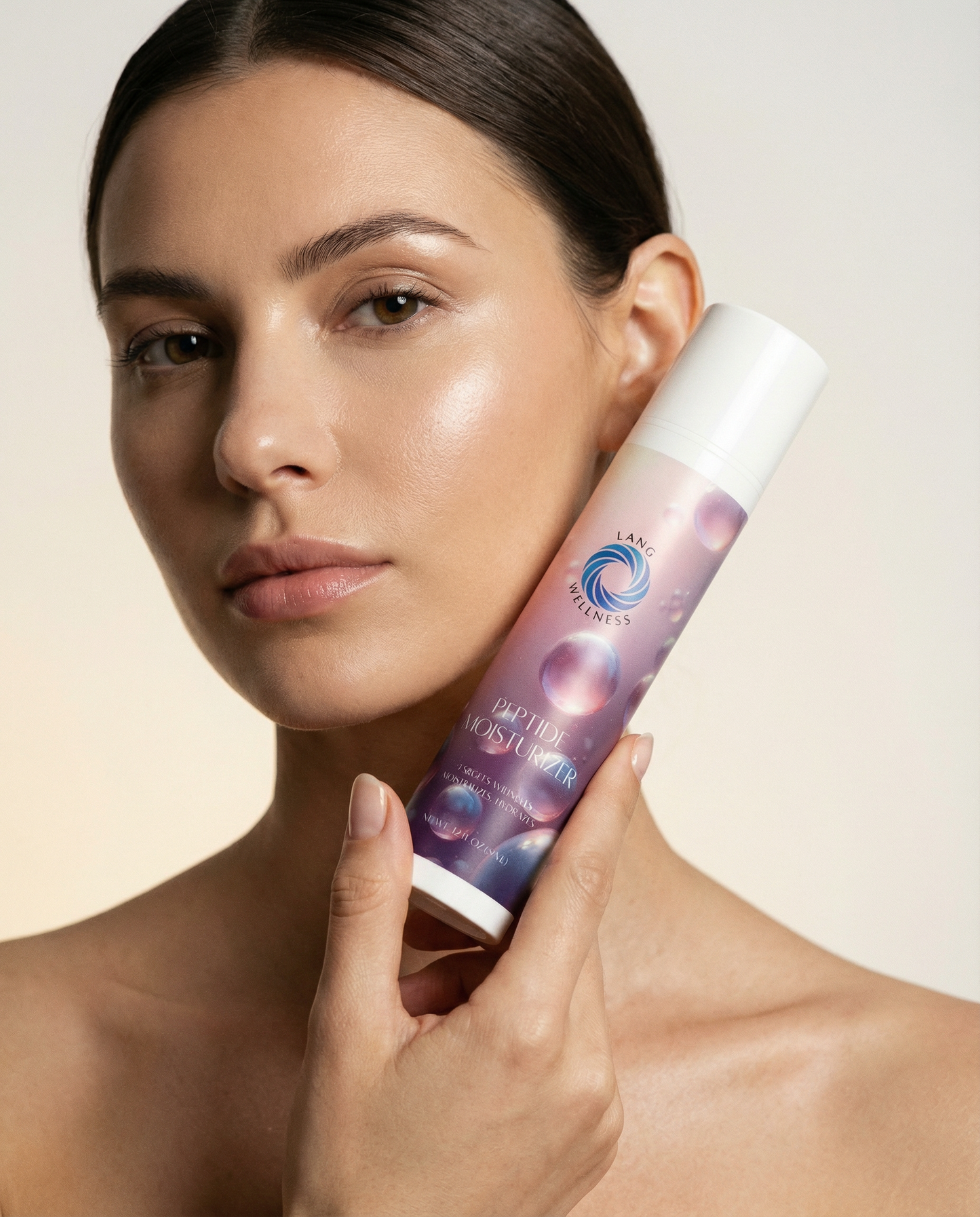 Moisturizer bottle with white cap and purple label held near a model’s cheek
