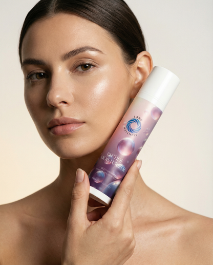 Moisturizer bottle with white cap and purple label held near a model’s cheek
