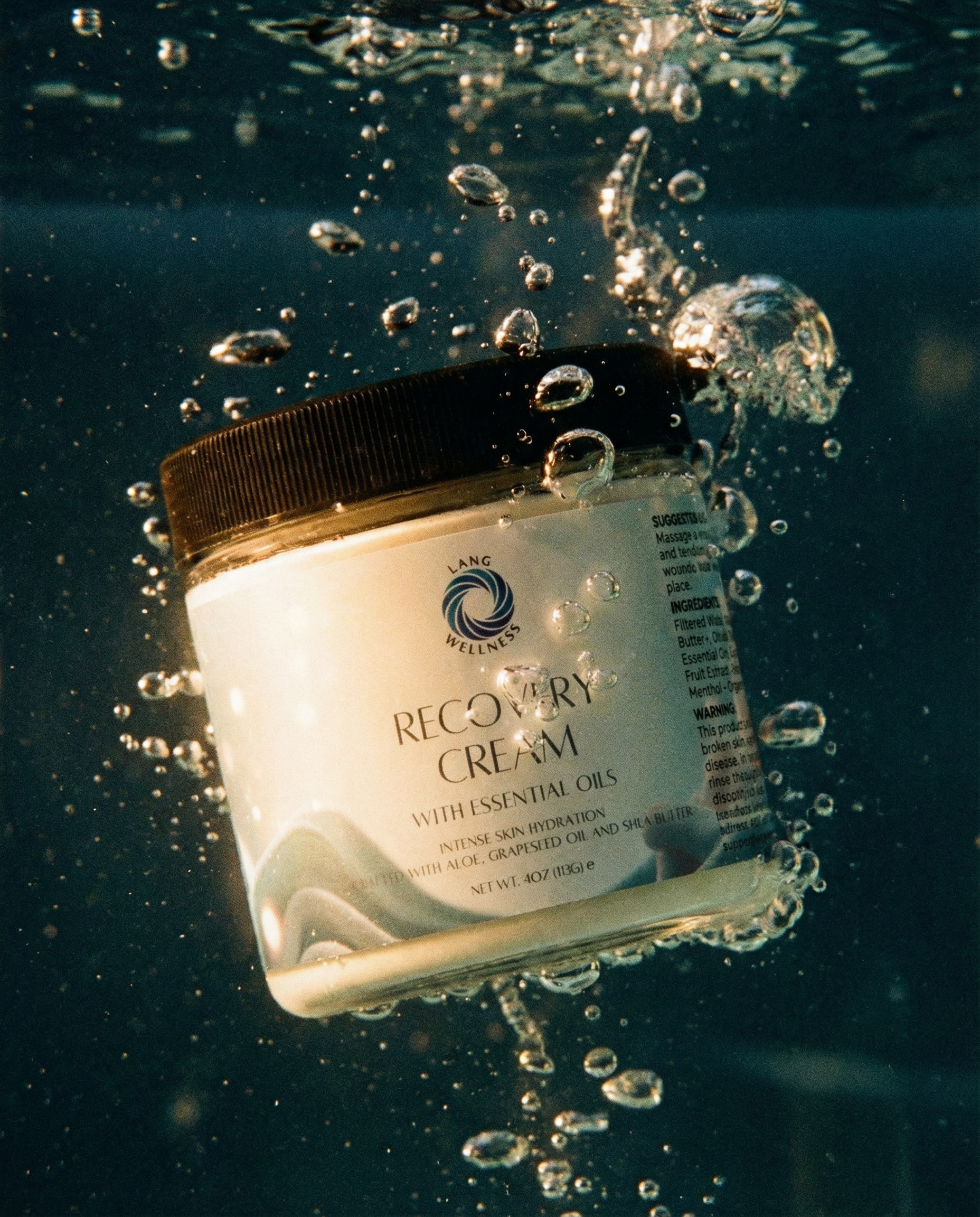 Recovery cream jar splashed with water droplets, black lid and white cream base