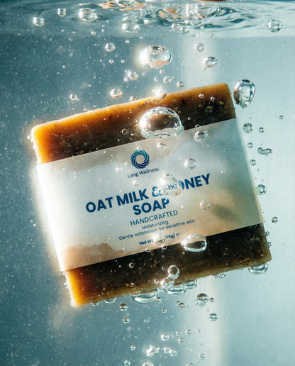 Oat milk & honey soap bar, amber-brown with blue label and water droplets