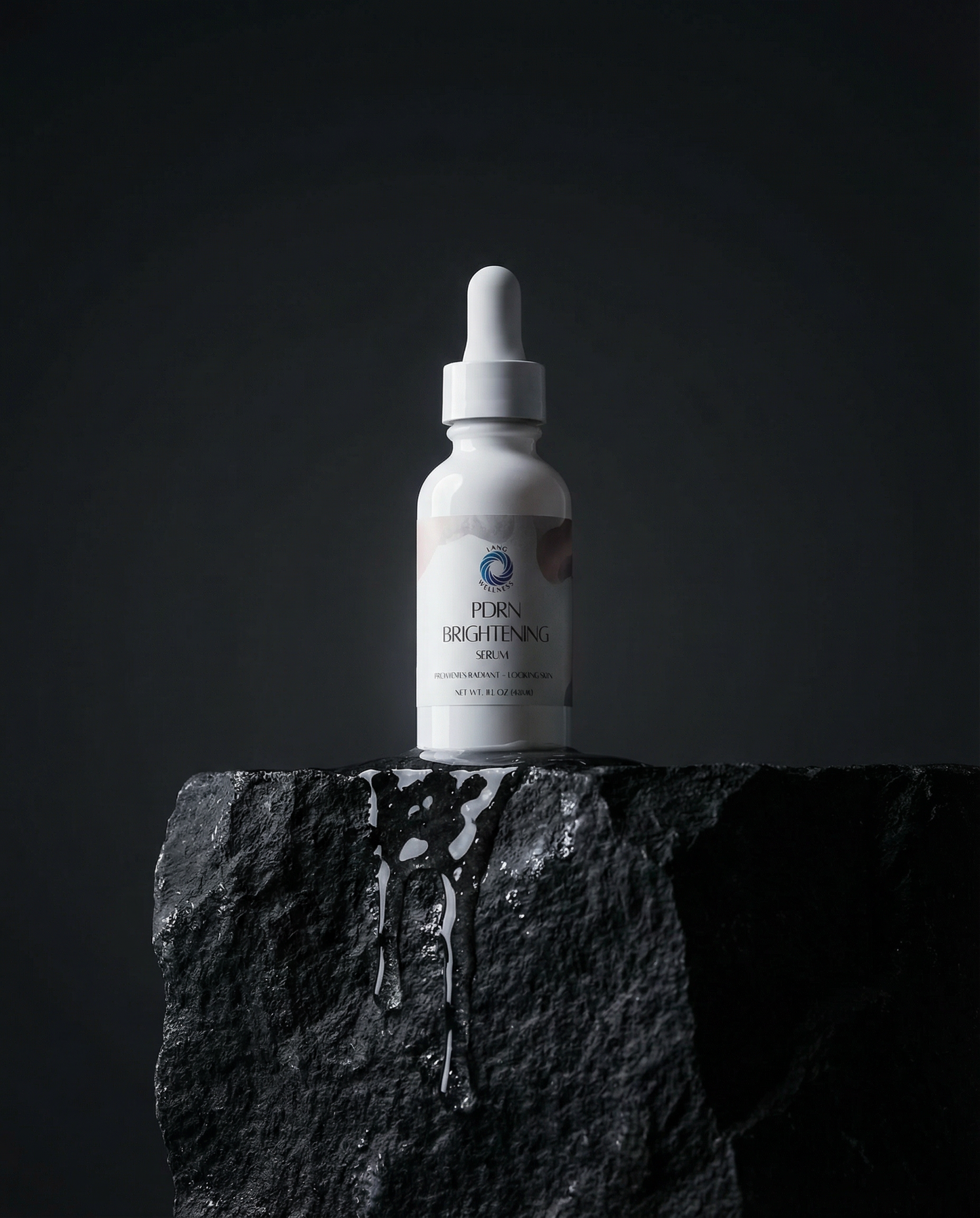 Brightening serum bottle with dropper on dark textured stone base