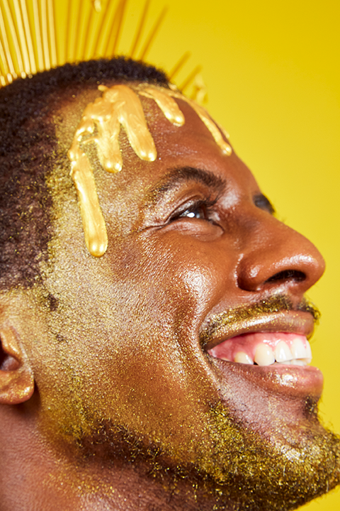 All-over cream highlighter with gold shimmer on skin, close-up