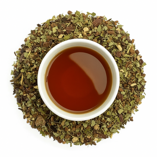 Cup of herbal tea with dark amber liquid surrounded by tea leaf flakes