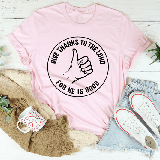 Pink crewneck T-shirt with thumbs-up scripture graphic and black text circle.