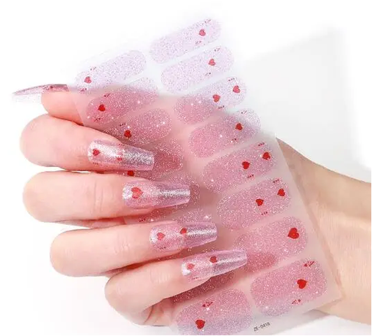 Glitter gel nails with pink shimmer and red hearts, long square tips