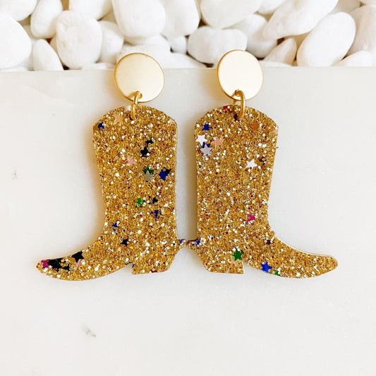 Gold glitter cowboy boot earrings with round gold hoop and dangling boot charms.