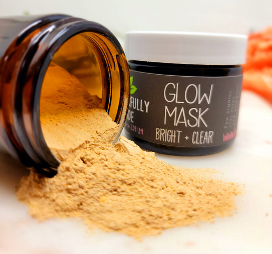 Turmeric clay mask jar with golden powder and black label reading Glow Mask Bright + Clear