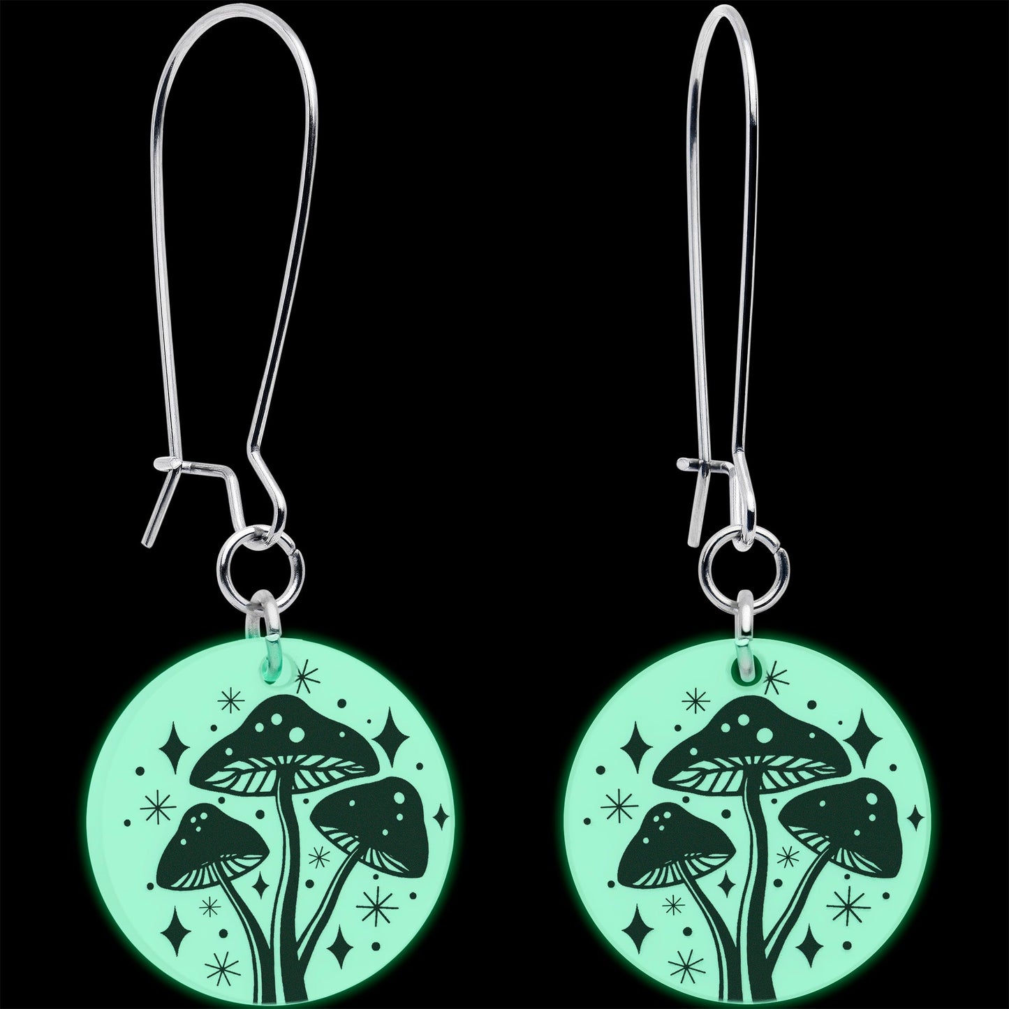 Silver dangle earrings with round mushroom charms glowing green under dark light