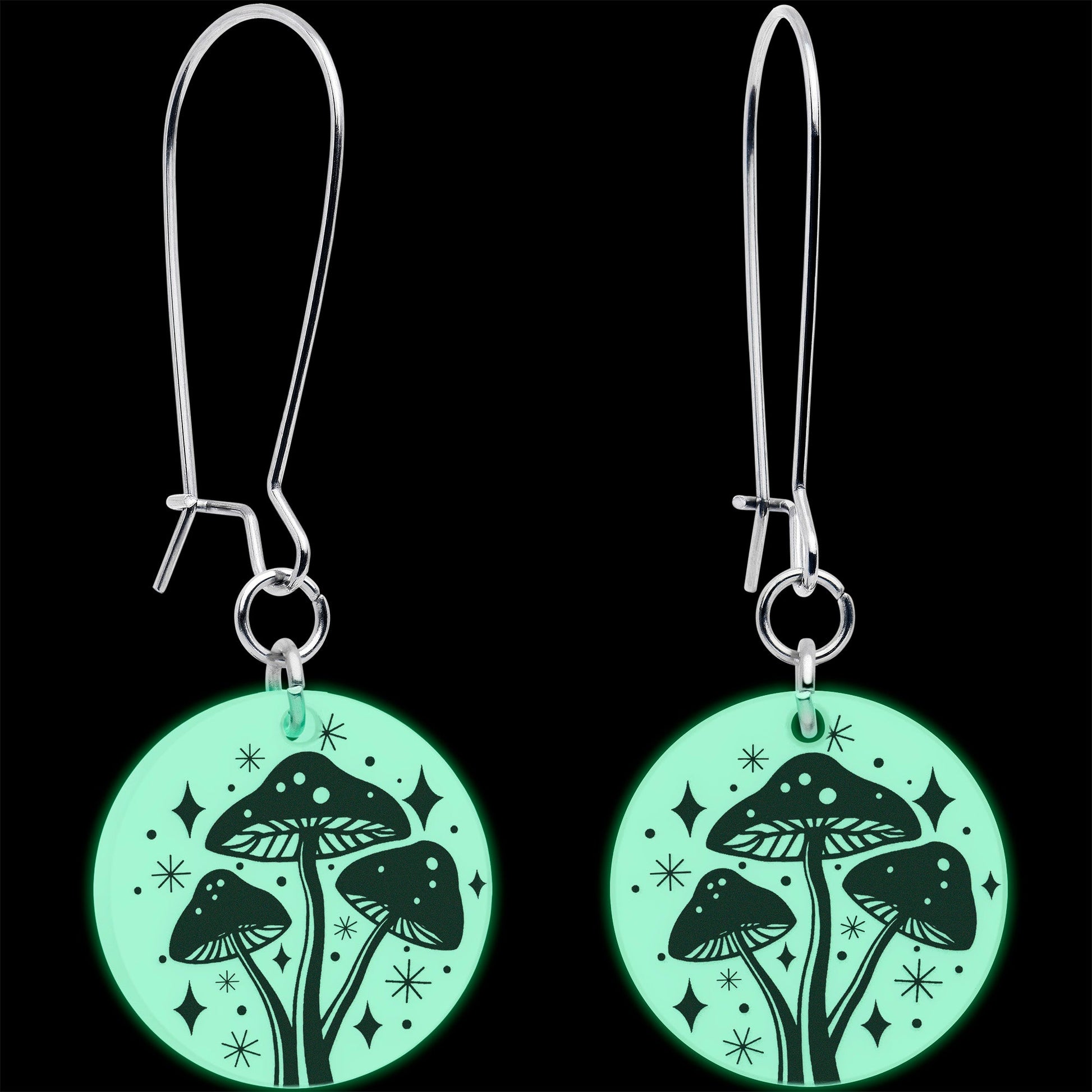 Silver dangle earrings with round mushroom charms glowing green under dark light