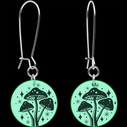 Silver dangle earrings with round mushroom charms glowing green under dark light