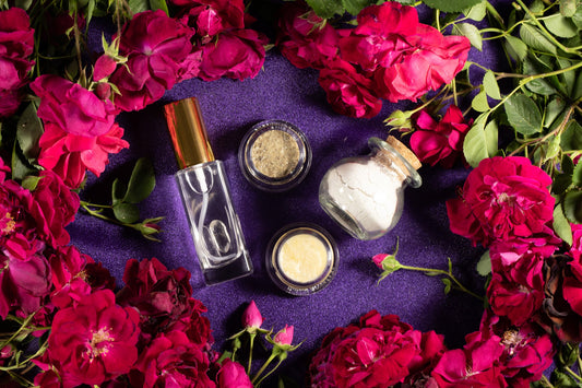 Spa bottles and small jars with gold caps surrounded by pink roses