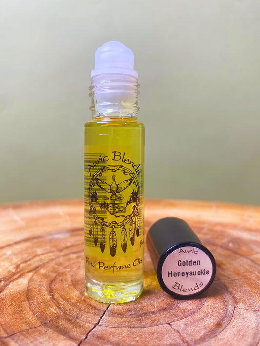 Roll-on perfume oil bottle with honey-gold liquid, white cap, and round black lid