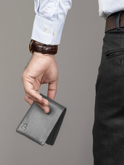 Gray bifold wallet held in hand, smooth leather with embossed mark