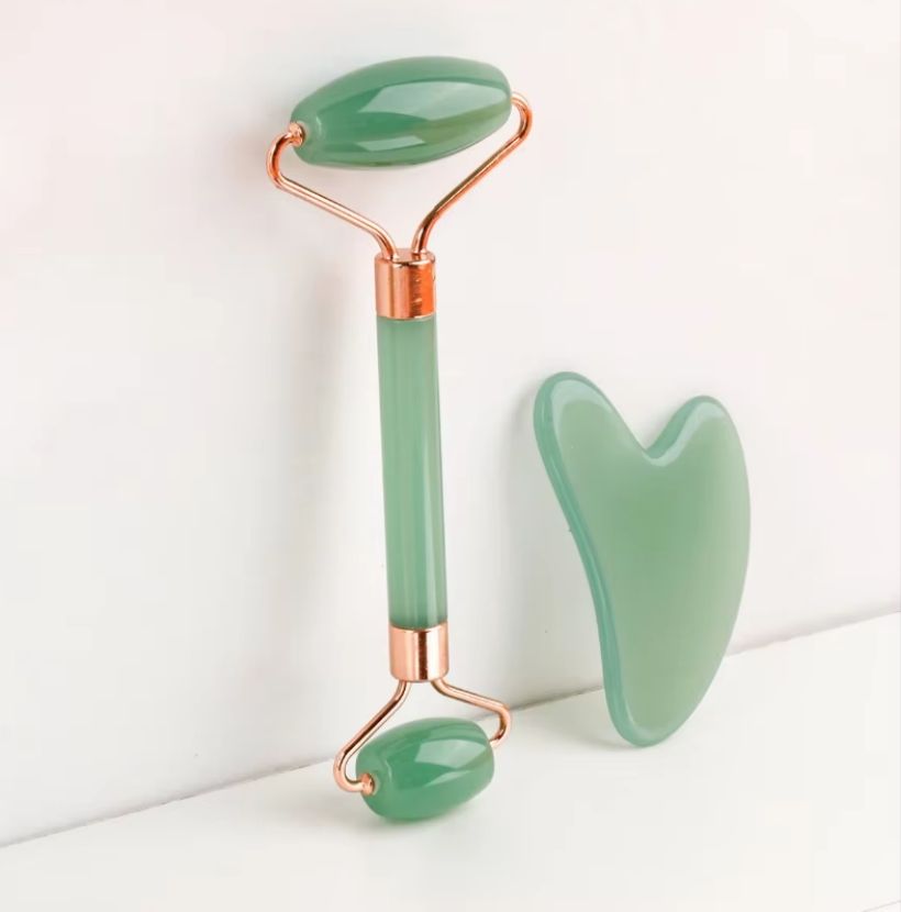 Green jade roller and gua sha tools with rose-gold metal frames