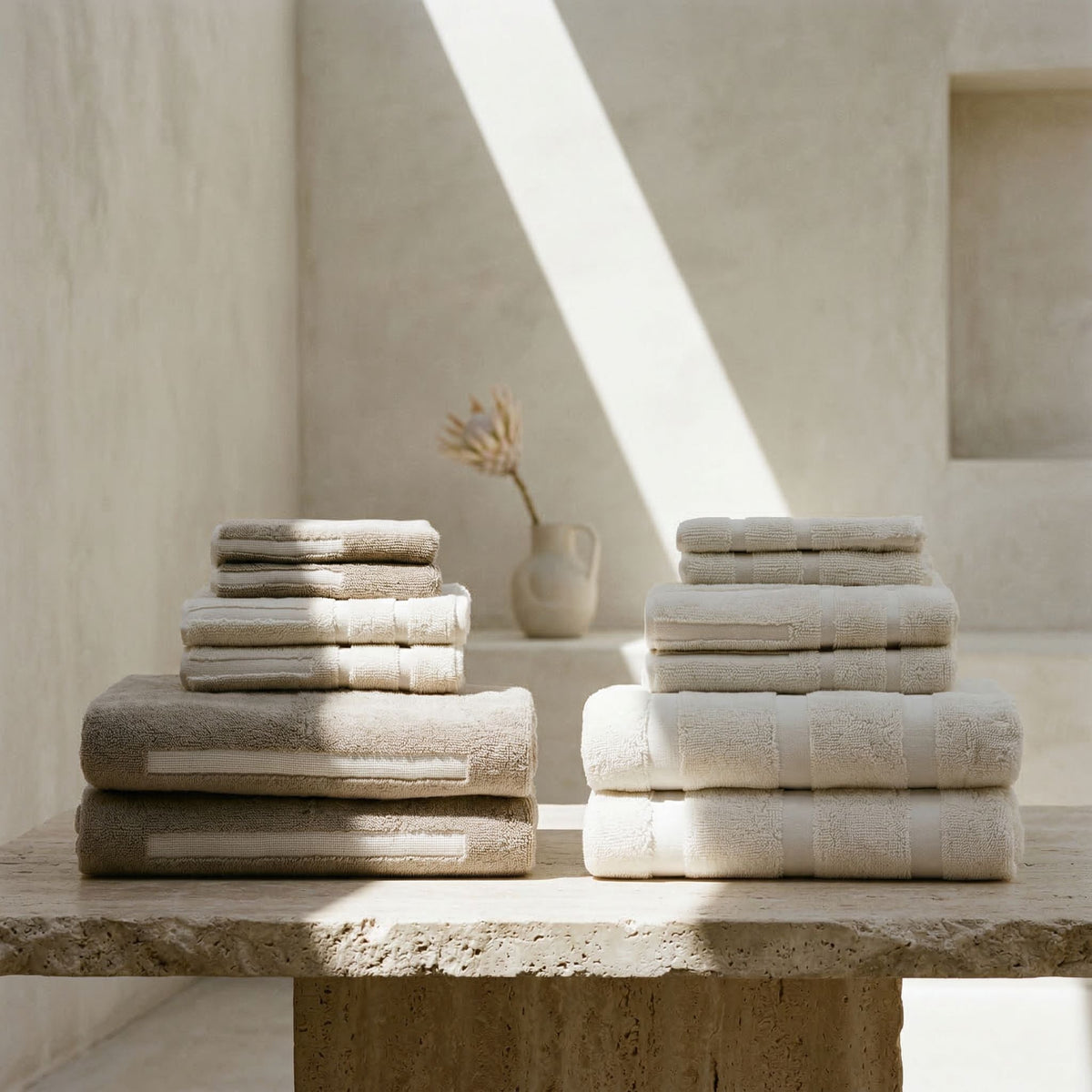 Stack of ecru cotton towels with folded washcloths, hand towels, and bath towels