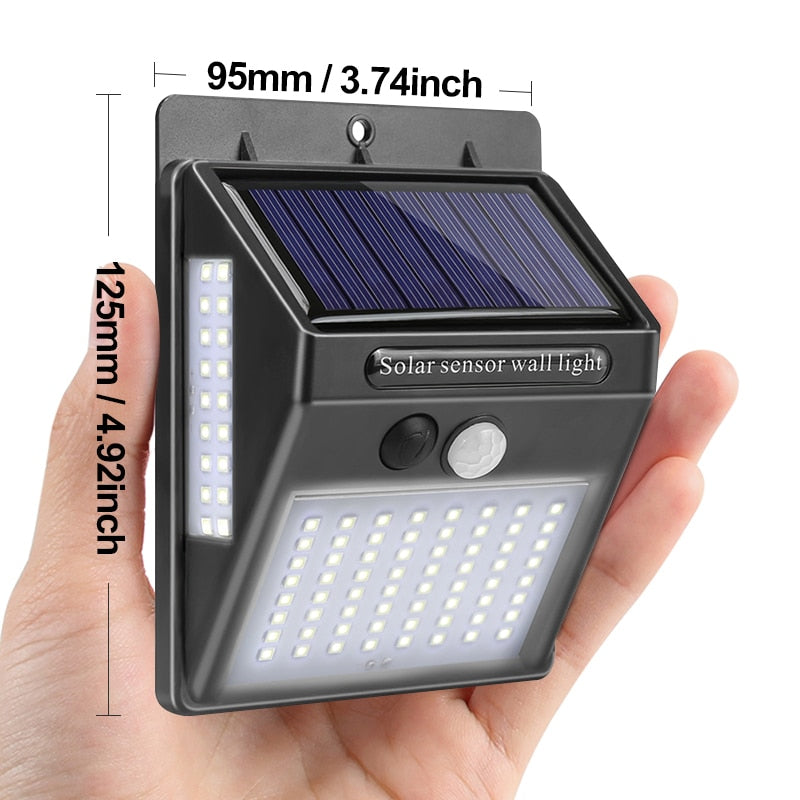 Black solar sensor wall light with solar panel, front LED arrays, and round motion sensor